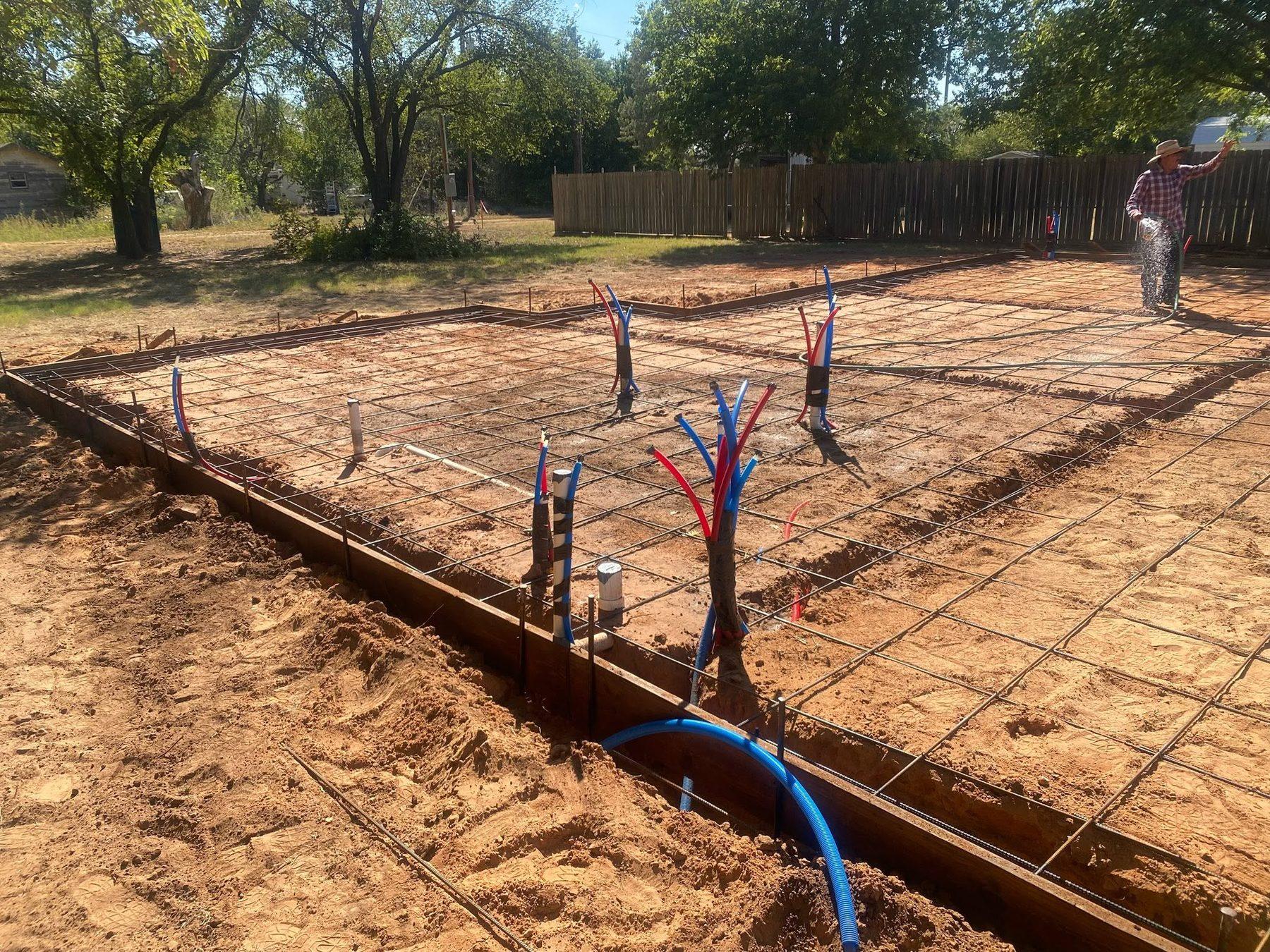 Rebar and plumbing set in forms ahead of a slab pour