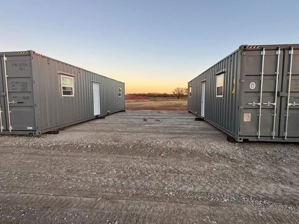 Container units facing each other across the gravel drive