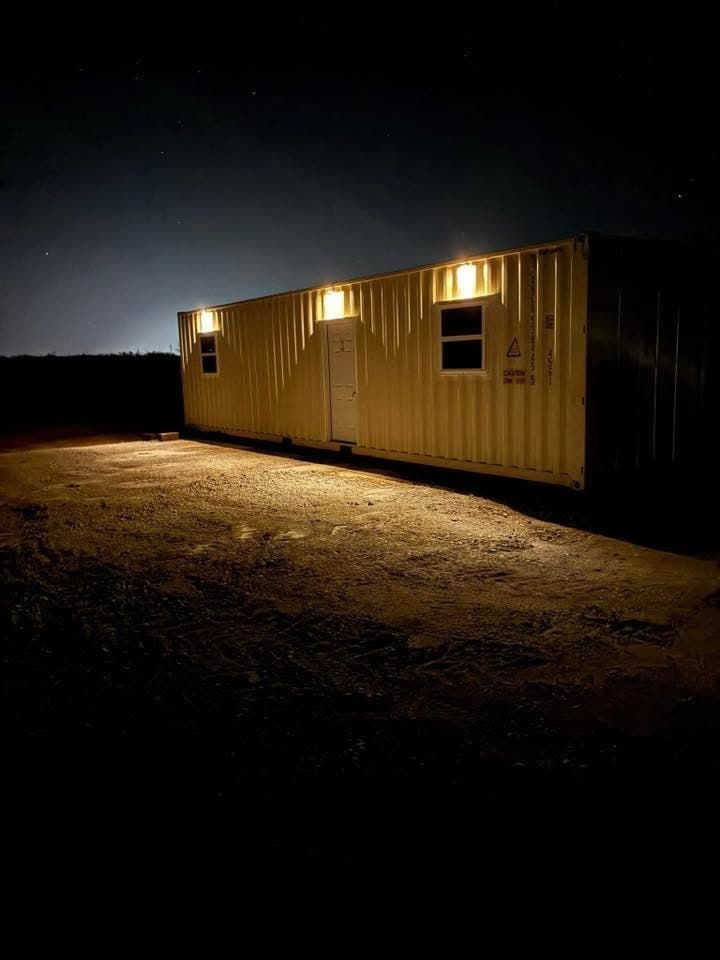 A container unit lit by its exterior lights at night